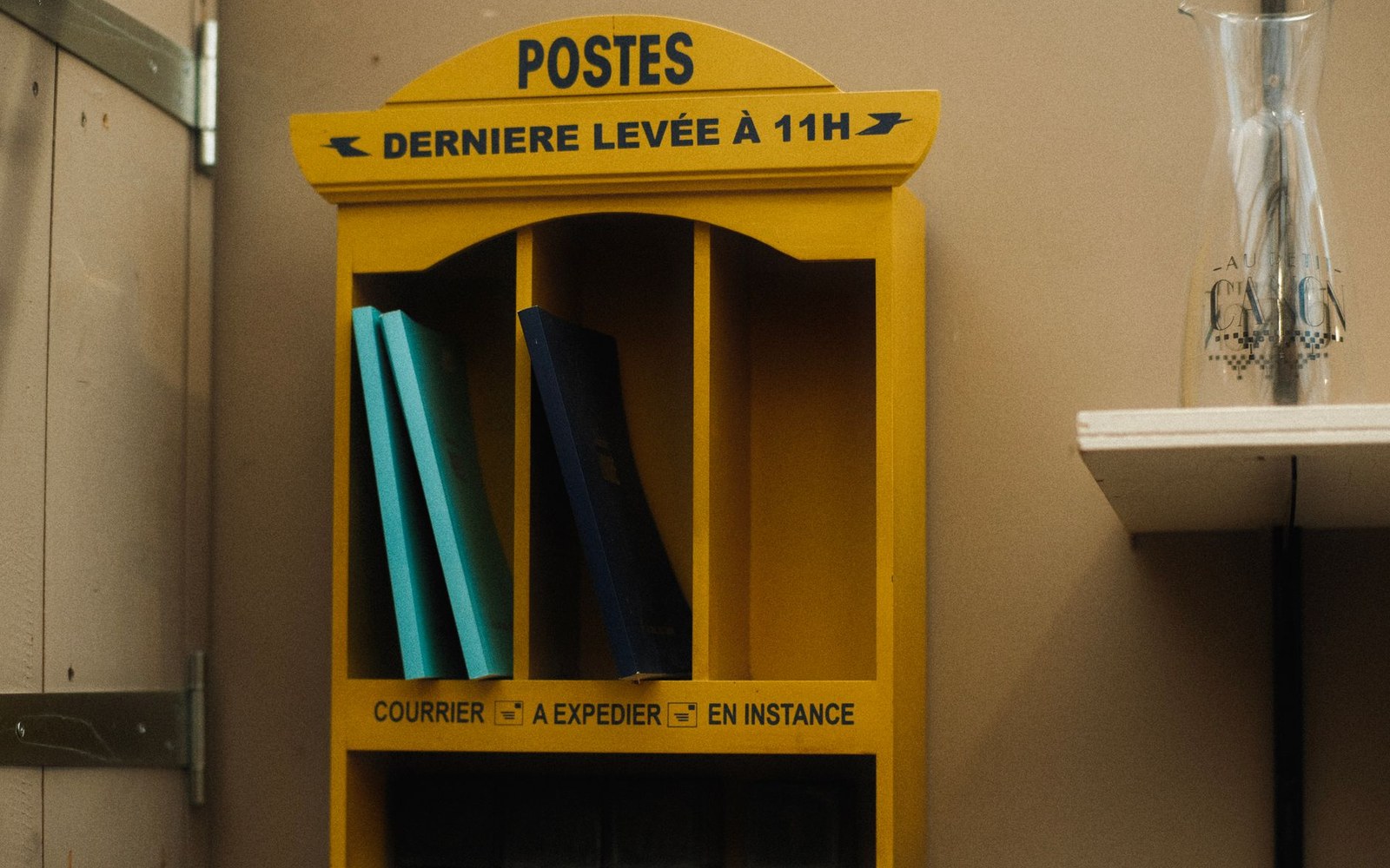 A wall of catalogue spines on a wooden shelf, shot close with raking light picking out the lettering
